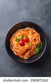 Pasta, Spaghetti With Tomato Sauce In Black Bowl On Grey Stone Background. Top View.