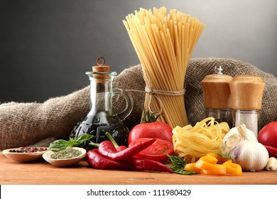 Pasta spaghetti, vegetables and spices, on wooden table, on grey background - Powered by Shutterstock