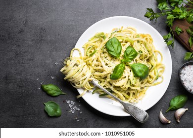 Pasta spaghetti with zucchini, basil, cream and cheese on black stone table. Vegetarian vegetable pasta. Zucchini noodles. Top view copy space.