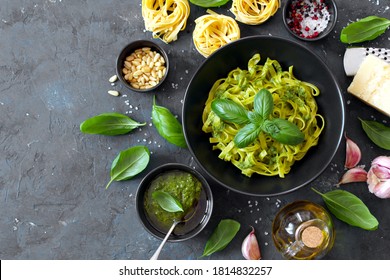 Pasta Tagliatelle With Pesto Sauce And Fresh Basil Leaves In Black Bowl. Top View With Copy Space.