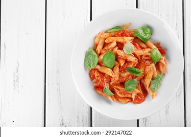 Pasta With Tomato Sauce And Basil On Wooden Table Close Up