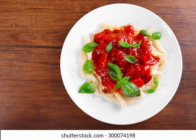 Pasta With Tomato Sauce And Basil On Wooden Table Close Up