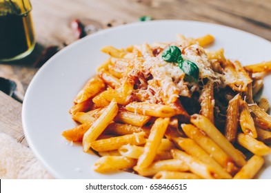 Pasta With Tomato Sauce And Basil On Wooden Table