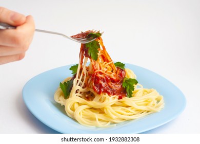 Pasta With Tomato Sauce And Herbs In A Blue Plate, Hand With Fork, White Background