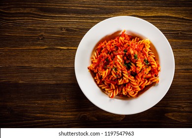 Pasta With Tomato Sauce And Vegtables On Wooden Table