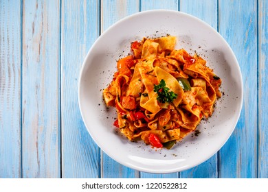 Pasta With Tomato Sauce And Vegtables On Wooden Table