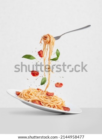 pasta with tomatoes and basil on a gray background