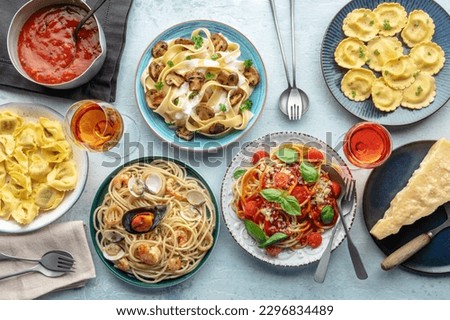 Pasta variety. Italian food and drinks, overhead flat lay shot. Spaghetti marinara, mushroom pappardelle, seafood pasta, wine, Parmesan cheese