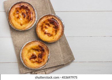 Pasteis De Nata, Typical Portuguese Egg Tart Pastries On A Set Table. Top View With Copy Space