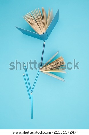 Pastel blue books and pencils on bright blue background. Education, knowledge or Nature concept. Flat lay.