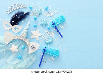 Pastel blue Purim (jewish carnival holiday) party decorations over wooden background. Flat lay, top view