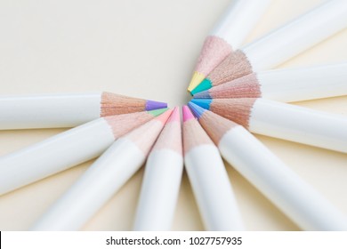 Pastel color pencils arrange in circle with copy space on light white paper background using as coloring or art for anti-stress and relaxation therapy.