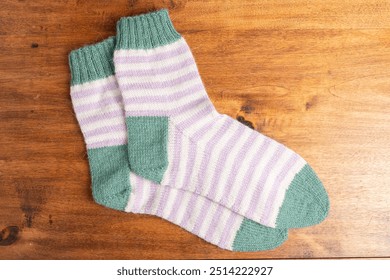 Pastel color striped handmade socks on a wooden table - Powered by Shutterstock