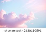 Pastel colored fluffy clouds float in a light blue sky creating soft aesthetic.