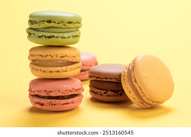 Pastel colored french macarons pastry of raspberry, lemon, chocolate and pistachio flavors on light yellow background - Powered by Shutterstock