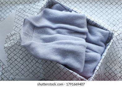 Pastel Colored Womens Clothing Folded In A Box On A White Background. Gift Organization Concept