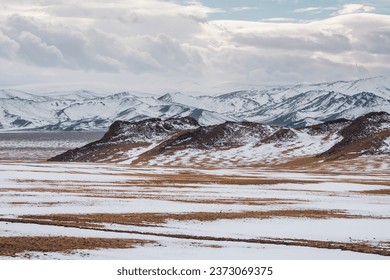 Pastel colors with the snow covered mountains in the distance. Scenic minimalist landscape with rocks in pastel tones. Snowy pasture scenery in winter. Mongolia landscapes. - Powered by Shutterstock