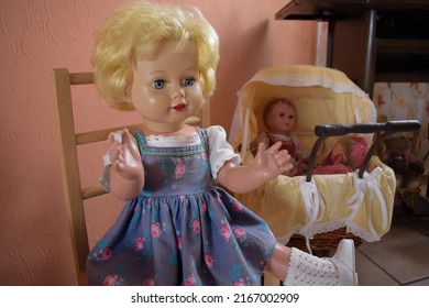 Pastel Coloured Vintage Child Doll From Germany Sitting On A Small Doll Chair