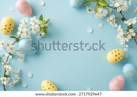 Pastel Easter scene featuring decorative eggs and white blossoms arranged in a circular frame on a soft blue background, conveying spring, celebration, and warm holiday greetings