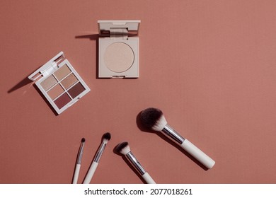 Pastel Eye Shadow Palette, Highlighting Powder And Makeup Brushes On Pink Background.