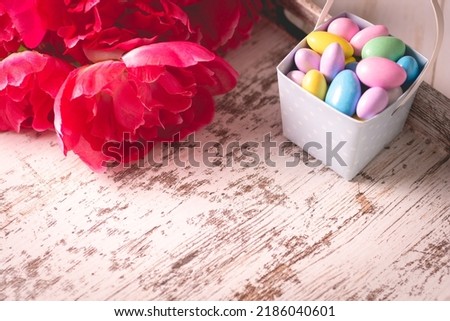 Pastel and hazy jordan almonds and flower on a wooden tray for M
