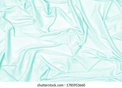 Pastel Mint Green Silk Fabric Texture. Light Turquoise Satin Cloth Folds Abstract Background