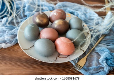 pastel and natural color eggs on plate with fork and knife.  wooden table with blue napkin - Shutterstock ID 1688091679
