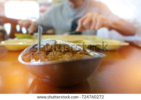pastel orange light  blur man eating curry Indian foods on table background