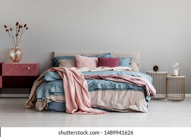 Pastel Pink, Beige And Blue Bedding On King Size Bed In Trendy Bedroom Interior, Copy Space On Empty Grey Wall