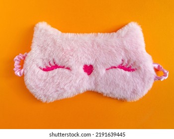 Pastel Pink Fluffy Fur Sleep Mask With Small Ears On Pastel Yellow Paper Background. Top View, Flat Lay. Concept Of Vivid Dreams. Accessories For Girls And Young Women.