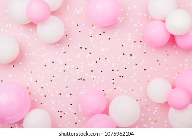 Pastel pink table with frame from balloons and confetti for birthday top view. Flat lay composition. - Shutterstock ID 1075962104