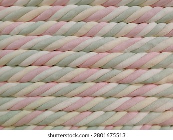 Pastel twisted marshmallow pattern background. Close-up texture of colorful twisted marshmallow ropes arranged in horizontal rows, soft candy confectionery backdrop in pink, white and mint green colors