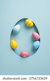 Pastel vertical decorated Easter egg arranged inside a cutout egg-shaped frame for a happy Easter greeting and celebration perfect for card, invitation or seasonal design