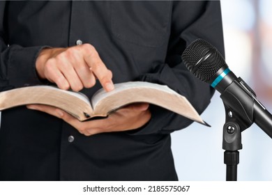 Pastor With A Bible In Hand During A Sermon. The Preacher Delivers A Speech