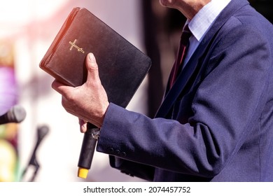 Pastor with a Bible in his hand during a sermon. The preacher delivers a speech - Shutterstock ID 2074457752