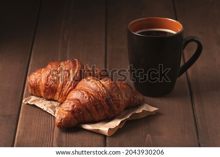 Pastries,Croissants on a brown wooden table, with a cup of coffee, breakfast, no people, rustic style,