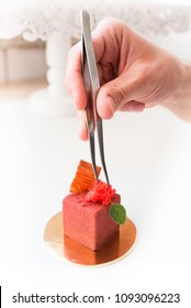 Pastry Chef Adjusting Decoration On An Exquisite Dessert With Food Tweezers