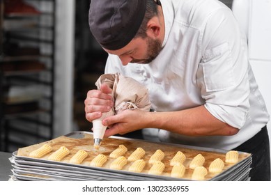 Pastry Chef With Confectionary Bag Squeezing Cream At Pastry Shop .