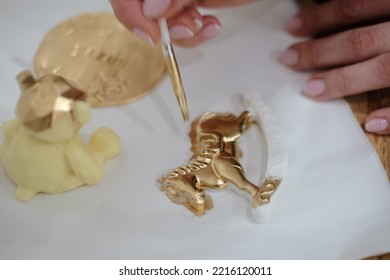 Pastry Chef Hands Draws With A Brush Golden Bear And Horse