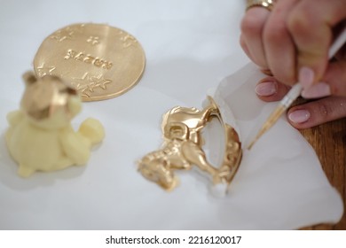 Pastry Chef Hands Draws With A Brush Golden Bear And Horse