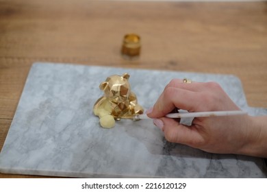 Pastry Chef Hands Draws With A Brush Golden Bear And Horse