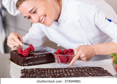 Pastry chef in the kitchen decorating a cake of chocolate - Powered by Shutterstock