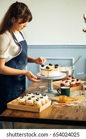 Pastry Chef In The Kitchen Decorating A Cake Of Chocolate,fruit,candies,Confectioner Is Decorating Chocolate Cake,cooking Class, Culinary, Bakery, Food And People Concept