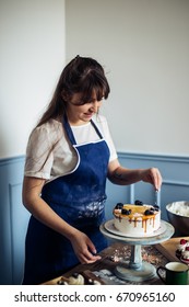 Pastry Chef In The Kitchen Decorating A Cake Of Chocolate,fruit,candies,Confectioner Is Decorating Chocolate Cake,cooking Class, Culinary, Bakery, Food And People Concept