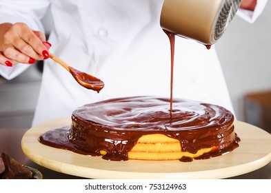 Pastry Chef In The Kitchen Decorating A Cake Of Chocolate