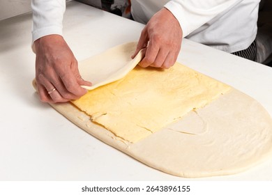 Pastry chef makes puff pastry. Selective focus.