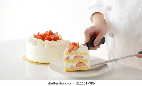 pastry chef serving strawberry cake isolated on white background. - Shutterstock ID 2111517386
