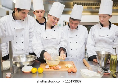 Pastry chef showing students how to prepare dough in kitchen - Powered by Shutterstock