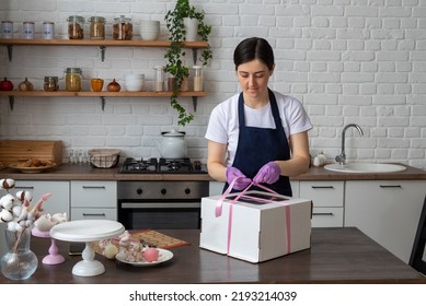 The Pastry Chef Ties Ribbon On The Package With The Cake For Delivery. Selective Focus. Photos About Confectioners, Food, Hobbies.