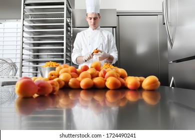 pastry chef at work in professional kitchen, makes apricot jam for the cake or for the croissants, on stainless steel worktop - Powered by Shutterstock